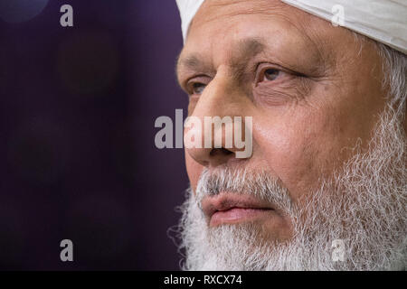 His Holiness Hazrat Mirza Masroor Ahmad speaks at a press conference during the National Peace Symposium, at the Baitul Futuh Mosque, in Morden, London. Stock Photo