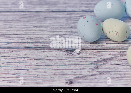 yellow and blue dragee eggs on a white wooden background, macro color photo Stock Photo