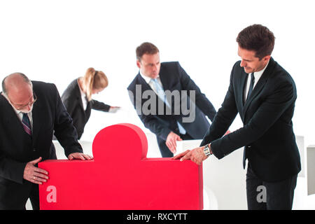 Business teamwork and problem solution concept . Business people with giant puzzle pieces . Partnership and collaboration , studio isolated on white b Stock Photo