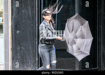 Woman in the wind, windswept, bad hair day, wind blown, long hair, female, face, head and shoulders, tangled tresses in a UK storm Preston, UK Stock Photo