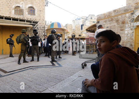 March 9, 2019 - Hebron, West Bank, Palestinian Territory - Israeli policemen stand guard, as Jewish settlers tour the Palestinian side of the old city market in Hebron in the occupied West Bank, on March 09, 2019  (Credit Image: © Wisam Hashlamoun/APA Images via ZUMA Wire) Stock Photo