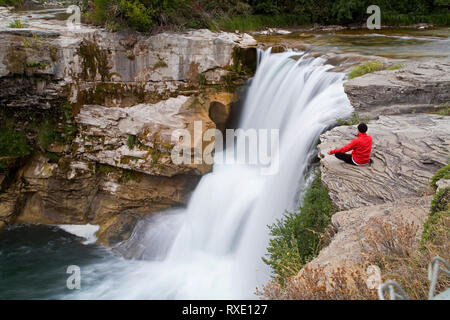 Middle age male meditating next to waterfall, Lundbreck Falls, Alberta, Canada Stock Photo