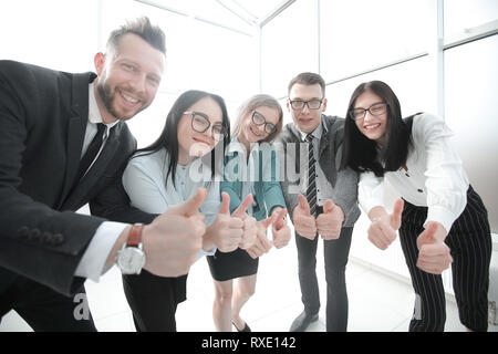 smiling business team looking at the camera and showing thumbs up Stock Photo