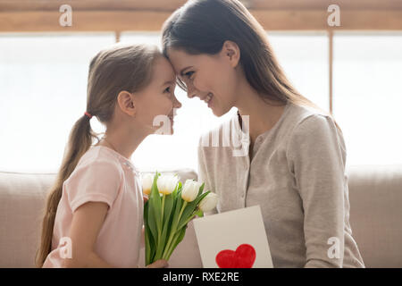 Cute little kid daughter congratulating happy mom with mothers day Stock Photo