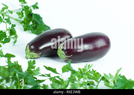 closeup.eggplants and sprigs of parsley isolated on white background Stock Photo
