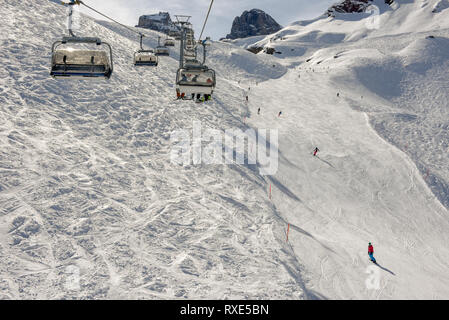 Engelberg, Switzerland - 3 March 2019: People skiing and going up the mountain by chairlift at Engelberg on the Swiss alps Stock Photo