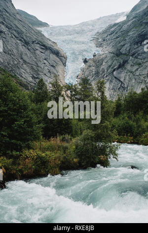 Glacier Retreat - The retreating Briksdal Glacier and melt water river in Briksdalsbreen an arm of the larger Jostedalsbreen glacier in Stryn Norway. Stock Photo