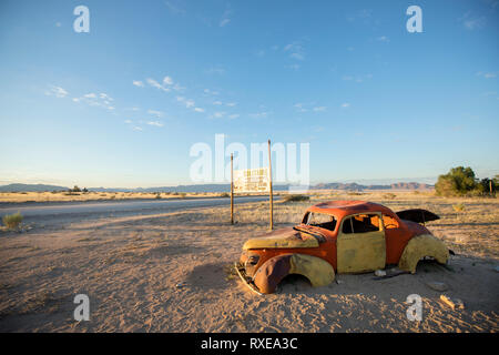 Discarded old cars sit by the road in the south of Namibia at Solitaire. Stock Photo