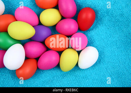 Multi colored easter eggs against a bright blue wool blanket background. Stock Photo