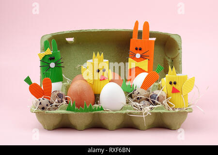 Easter holiday concept with eggs, cute handmade bunny, chicks in papaer box for egg, sptingtime background Stock Photo