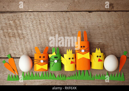 Cute creative photo with easter eggs, papaer cratf diy chiken and the Easter Bunny, holiday springtime concept, copy space Stock Photo