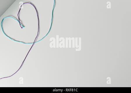 Heart symbol designed from yarn wools threads on white background with copy space. Stock Photo