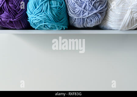 Top view of colored yarn balls in white wooden box with copy space under it. Stock Photo