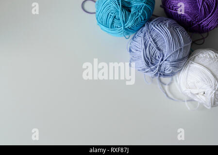 Creative decoration of colorful knitting wools for handmade on white table with copy space. Stock Photo