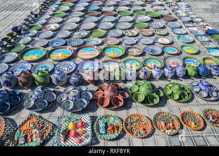 BUKHARA, UZBEKISTAN - OCTOBER 19, 2016: Souvenir trade on the street in Bukhara. Decorative plates, tea sets, teapots and other ceramic products are o Stock Photo
