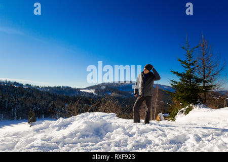 Beautiful panorama with young tourist having long trekking taken in polish mountains Beskidy on the way to Rysianka during snowy winter. Landscape wit Stock Photo