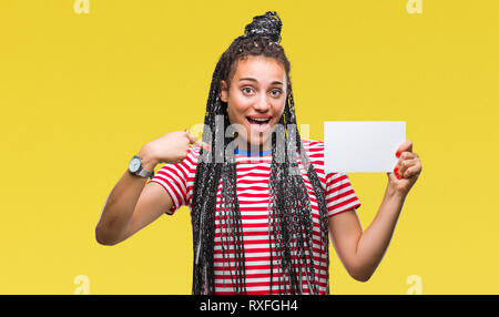 Young african american girl holding blank card over isolated background with surprise face pointing finger to himself Stock Photo