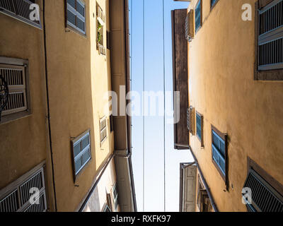 Travel to Italy - bottom view of blue sky between apartment houses on narrow street via Bartolomeo Colleoni in Citta Alta (Upper Town) of Bergamo city Stock Photo