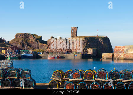 Dunbar harbour and Dunbar Castle with lobster creels in the foreground. background. Dunbar, East Lothian, Scotland Stock Photo