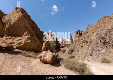 Views within the Charyn Canyon to the reddish sandstone cliffs. The canyon is also called valley of castles and is located east of Almaty in Kazakhsta Stock Photo