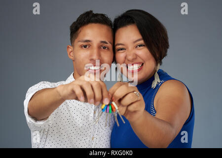 Happy latina young couple holding house key Stock Photo