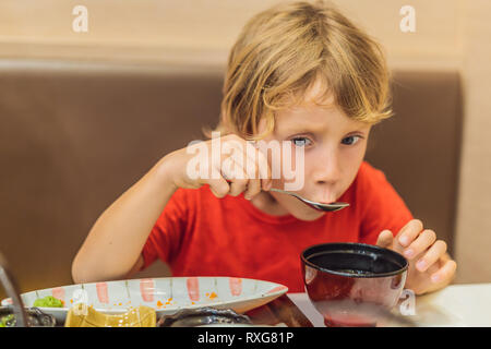 Little boy eating japanese soup in the japanese restaurant. Stock Photo