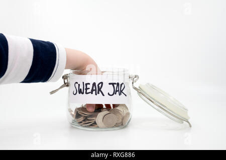 Childs hand right inside the swear jar either putting in or taking out coins Stock Photo