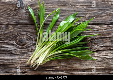 Fresh young wild garlic leaves on a rustic background Stock Photo