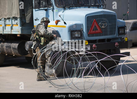 (190310) -- SRINAGAR, March 10, 2019 (Xinhua) -- An Indian paramilitary soldier lays barbed wire on a street during a security lockdown in downtown area of Srinagar, the summer capital of Indian-controlled Kashmir, March 10, 2019. Authorities on Sunday imposed restrictions in parts of Srinagar city to prevent protests after India's anti-terror agency, National Investigation Agency (NIA),  summoned key separatist leader and chief cleric of Indian-controlled Kashmir for questioning in an alleged funding case, officials said on Saturday. Mirwaiz Umar Farooq has been asked to appear before the pro Stock Photo