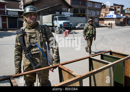 (190310) -- SRINAGAR, March 10, 2019 (Xinhua) -- Indian paramilitary soldiers stand guard near a barricade during a security lockdown in downtown area of Srinagar, the summer capital of Indian-controlled Kashmir, March 10, 2019. Authorities on Sunday imposed restrictions in parts of Srinagar city to prevent protests after India's anti-terror agency, National Investigation Agency (NIA), summoned key separatist leader and chief cleric of Indian-controlled Kashmir for questioning in an alleged funding case, officials said on Saturday. Mirwaiz Umar Farooq has been asked to appear before the probe Stock Photo