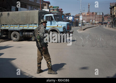 (190310) -- SRINAGAR, March 10, 2019 (Xinhua) -- An Indian paramilitary soldier stands guard near barbed wire barricade during a security lockdown in downtown area of Srinagar, the summer capital of Indian-controlled Kashmir, March 10, 2019. Authorities on Sunday imposed restrictions in parts of Srinagar city to prevent protests after India's anti-terror agency, National Investigation Agency (NIA), summoned key separatist leader and chief cleric of Indian-controlled Kashmir for questioning in an alleged funding case, officials said on Saturday. Mirwaiz Umar Farooq has been asked to appear bef Stock Photo