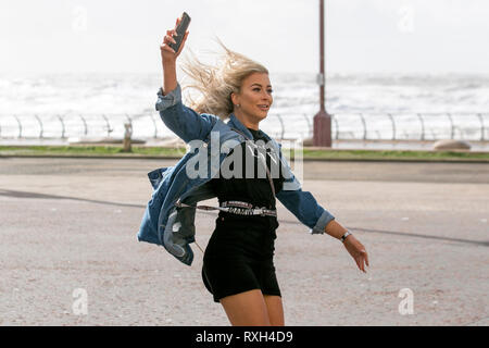 Tangled tresses on a bad hair fun day in Blackpool, Lancashire, UK. 10th March, 2019. Strong gale force winds at the coast. Tracy, windswept as the strong blustery winds sweep through the town centre. Weather warnings have been issued over the north west of England for severe gusts and rain over the weekend. Stock Photo