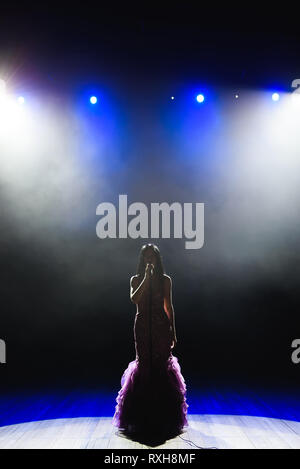 female singer on stage with smoke effect screen at night Stock Photo ...