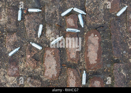 Discarded canisters that once contained nitrous oxide, commonly used by teenagers for the effect of the drug for recreational purposes Stock Photo