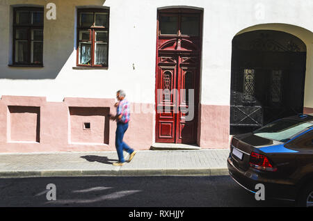 Red Old Wood Door. Ancient Door on the Facade of a Building in a Narrow Street. Travel Background Stock Photo