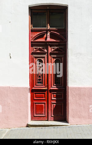 Red Old Wood Door. Ancient Door on the Facade of a Building in a Narrow Street. Travel Background Stock Photo