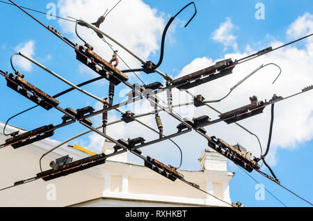 Wires for Trolley at the Intersection Against Blue Sky. Crossing of Power Lines at a Crossroads for Land Public Transport Stock Photo