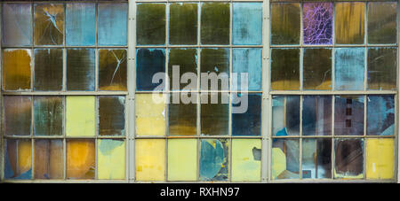Abstract Background Of Grungy Coloured Panes Of Glass In A Factory Window Stock Photo