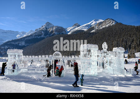 LAKE LOUISE, CANADA - FEBRUARY 18 2019: People enjoying the winter outdoors on the frozen Lake Louise. Some people building an ice castle, while other Stock Photo