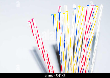Multicolored stripes party candles on a white backdrop Stock Photo