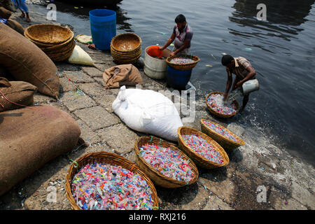 Recycled plastic chips washing in the polluted water of Buriganga River. Dhaka, Bangladesh. Stock Photo