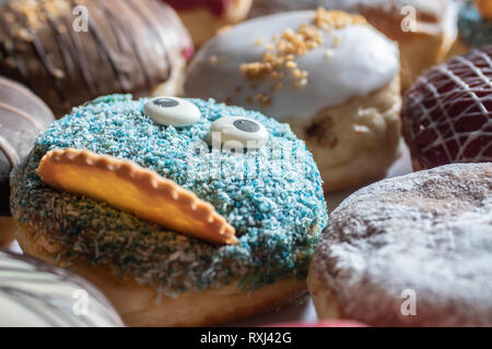 Delicious freshly baked cream donut sprinkled with powdered sugar cooling on a wire rack in the kitchen Stock Photo