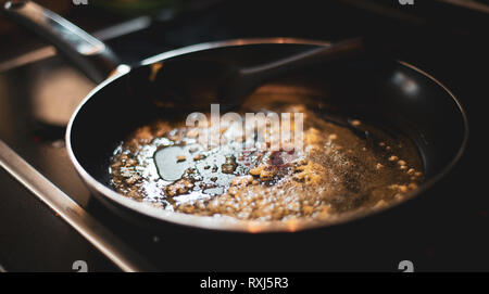 Cooking Butter and Garlic in a black pan Stock Photo