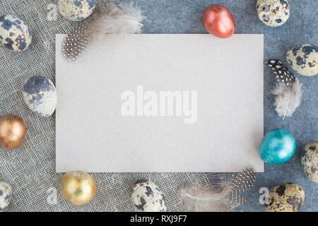 Easter greeting card with copy space for text and beautiful decor of eggs and feathers on fabric background pastel colored template for design Stock Photo