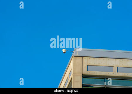 Security camera on tp of a building on a sunny day Stock Photo