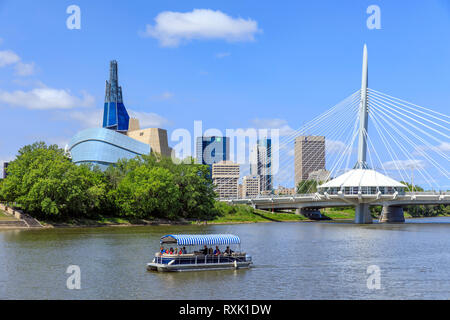 A water bus tour boat on the Red River, with the Canadian Museum for Human Rights, and skyline of Winnipeg, Manitoba, Canada Stock Photo