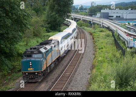 A Westcoast Express commuter train is lead by a VIA locomotive in Coquitlam, British Columbia, Canada. Stock Photo