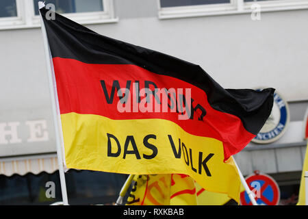 Landau, Germany. 9th March 2019. A protester carries a German flag with 'We are the people'written on it. Around 80 people from right-wing organisations protested in the city of Landau in Palatinate against the German government and migrants. They also adopted the yellow vests from the French yellow vest protest movement (Photo by Michael Debet Credit: PACIFIC PRESS/Alamy Live News Stock Photo