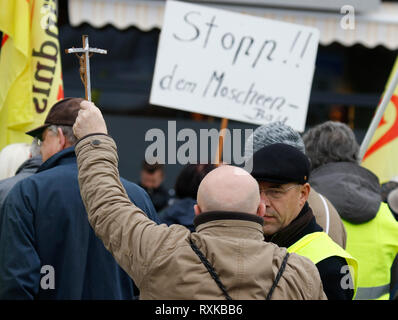 Landau, Germany. 9th March 2019. A protester holds up a crucifix. Around 80 people from right-wing organisations protested in the city of Landau in Palatinate against the German government and migrants. They also adopted the yellow vests from the French yellow vest protest movement (Photo by Michael Debets/Pacific Press) Credit: PACIFIC PRESS/Alamy Live News Stock Photo