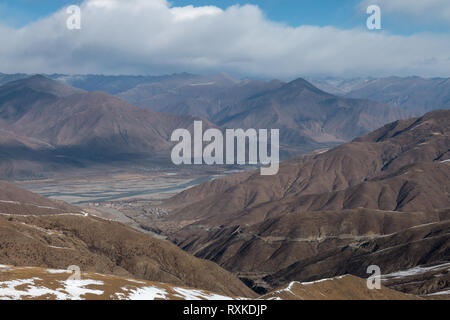 Snow covered mountain peaks in Tibet, on the journey to Everest Base Camp from Lhasa to Shigatse. Stock Photo
